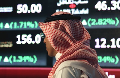 In this June 15, 2015, file photo, a Saudi man walks through the Tadawul Saudi Stock Exchange in Riyadh, Saudi Arabia. Image credit: AP Photo/Hasan Jamali, File