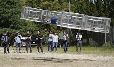 In this Saturday, June 3, 2017, file photo, Tsubasa Nakamura, project leader of Cartivator, third from left, watches the flight of the test model of the flying car on a former school ground in Toyota, central Japan. Image credit: AP Photo/Koji Ueda, File