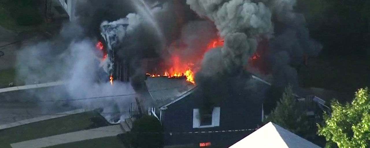 In this Sept. 13, 2018, file image take from video provided by WCVB in Boston, flames consume the roof of a home in Lawrence, Mass, a suburb of Boston. The pressure in natural gas pipelines prior to a series of explosions and fires in Massachusetts last week was 12 times higher than it should have been. The information was in a letter from the state's U.S. senators to the heads of Columbia Gas and NiSource. (WCVB via AP)