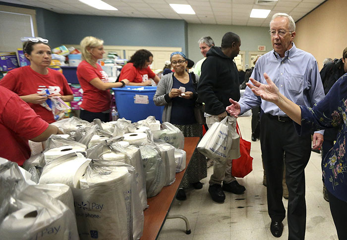 Columbia Gas CEO Steve Bryant, right, tours the Senior Center in Lawrence, Mass. where volunteers are handing out food and supplies, Tuesday, Sept. 18, 2018, in the wake of last week's gas explosions and house fires in the Merrimack Valley. Bryant earlier announced that the utility is donating $10 million to an emergency relief fund for people affected by the emergency. (AP Photo/Elise Amendola)
