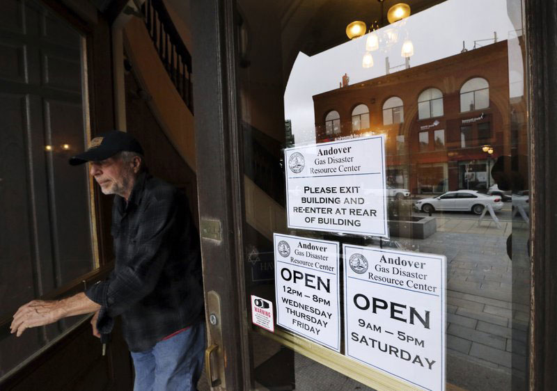 An Andover resident leaves old town hall which is open for claims and information, Wednesday, Sept. 19, 2018, in Andover, Mass., in the wake of last week's gas explosions and fires. About 8,600 customers were affected by the explosions, with many having to evacuate their homes for days, and some possibly having to go without gas service for weeks. (AP Photo/Elise Amendola)