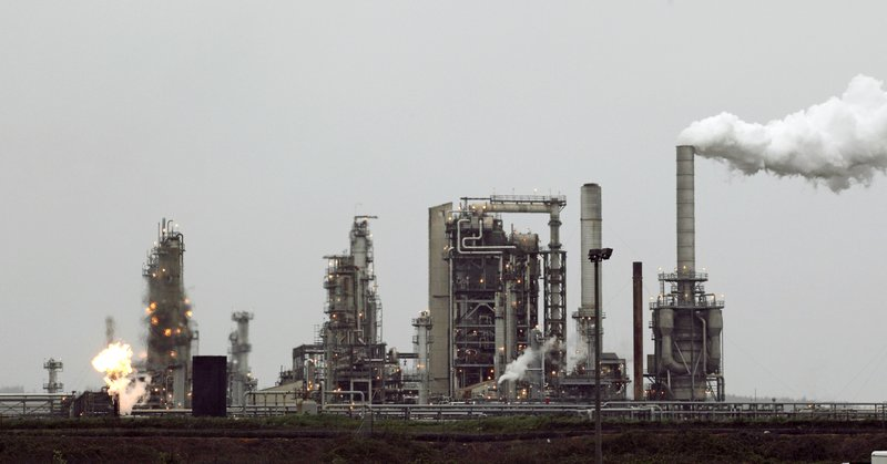 This April 2, 2010 file photo shows a refinery owned by Andeavor, formerly Tesoro Corp. including a gas flare flame that is part of normal plant operations, in Anacortes, Wash. A campaign bankrolled by the oil industry has raised $20.46 million to defeat a carbon pollution fee on the ballot in Washington state aiming at tackling climate change. (AP Photo/Ted S. Warren)