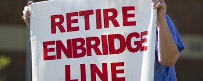 In this July 6, 2017, file photo, Lauren Sargent, takes part in a protest before the Enbridge Line 5 pipeline public information session in Holt, Mich. Officials tell The Associated Press that Michigan Gov. Rick Snyder's administration and Canadian pipeline giant Enbridge have reached a deal on replacing 65-year-old twin pipelines in a channel linking two of the Great Lakes. An announcement was scheduled for Wednesday Oct. 3, 2018. Officials tell the AP the agreement calls for shutting down the Line 5 pipes in the Straits of Mackinac connecting Lakes Huron and Michigan. (Cory Morse/The Grand Rapids Press via AP File)