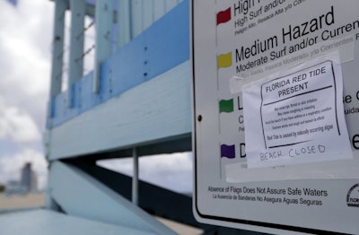 A sign posted on a lifeguard station warns of red tide at Haulover Beach Park, Thursday, Oct. 4, 2018, in Miami. Miami-Dade County closed beaches north of the Haulover inlet due to a rare outbreak of red tide along Florida's Atlantic Coast. Red tide is caused by algae and is common on Florida's Gulf Coast. (AP Photo/Lynne Sladky)