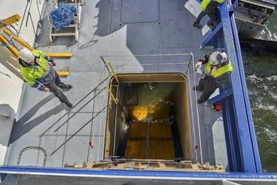 In this photo taken taken Thursday Sept. 27, 2018, staff onboard the Finnish icebreaker Polaris monitor the deployment of an oil spill recovery system, a first for an icebreaker. With the vessel positioned in the path of an oil spill, large booms trap pollutants, pushing them into hull of the ship. A skimmer with brushes then separates seawater from the oil, which is stored in large tanks. (AP Photo/David Keyton)