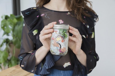 This undated photo provided by Man Repeller shows Lauren Singer in New York holding her mason jar containing one years worth of waste she produced. Once an industrial term, Zero Waste has become a rallying cry for a small but influential number of households trying to winnow their annual trash to, well, zero. From California to Canada to Brooklyn and beyond, a small but growing number of households are joining together in what has become what seems to be a movement, declaring that less may be more, but zero is the best of all, at least where contributing to landfills is concerned. (Bridget Badore/Man Repeller via AP)