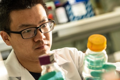 Rice University graduate student Danning Zhang, who led the development of a particle that attracts and degrades contaminants in water, checks a sample in a Rice environmental lab. (Jeff Fitlow/Rice University)