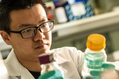 Rice University graduate student Danning Zhang, who led the development of a particle that attracts and degrades contaminants in water, checks a sample in a Rice environmental lab. (Jeff Fitlow/Rice University)