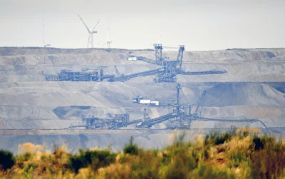In this Sept. 7, 2018 file photo bucket wheels dig for coal near the Hambach Forest near Dueren, Germany. On Friday, Oct. 5, 2018 a German court has ordered a temporary halt to plans to fell part of a forest in the west of the country to allow the expansion of a coal mine. (AP Photo/Martin Meissner)