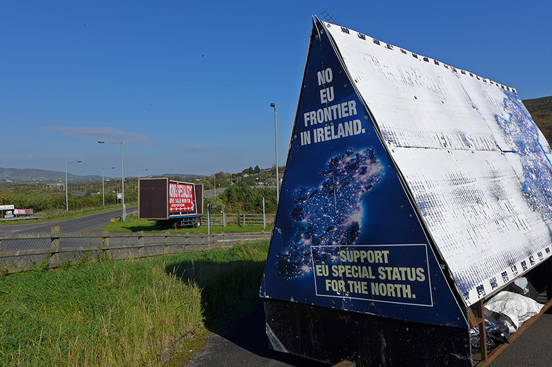 In this photo taken on Wednesday, Oct. 10, 2018, a sign in a parking lot of a cemetery reads: 'No EU border in Ireland' near Carrickcarnan, Ireland, just next to the Jonesborough Parish church in Northern Ireland. (AP Photo/Lorne Cook)