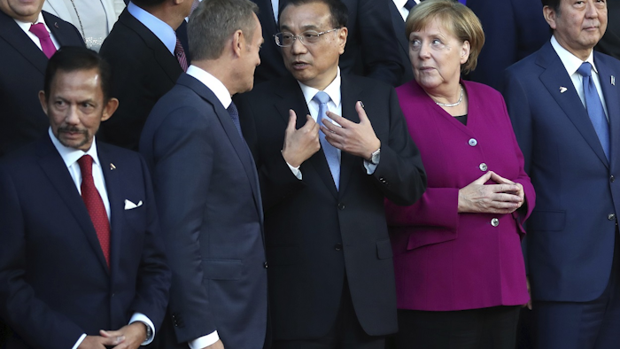 China's Prime Minister Li Keqiang, center, speaks with German Chancellor Angela Merkel, second right, and European Council President Donald Tusk, second left, during a group photo during an EU-ASEM summit in Brussels, Friday, Oct. 19, 2018. Image credit: AP Photo/Francisco Seco
