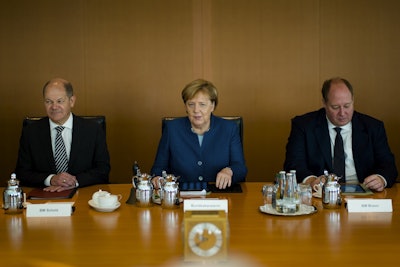 German Chancellor Angela Merkel sits between Vice-chancellor and Finance Minister Olaf Scholz, left, Head of Chancellery and Minister for Special Tasks Helge Braun, right, as she leads the weekly cabinet meeting of the German government at the chancellery in Berlin, Wednesday, Oct. 24, 2018. Image credit: AP Photo/Markus Schreiber