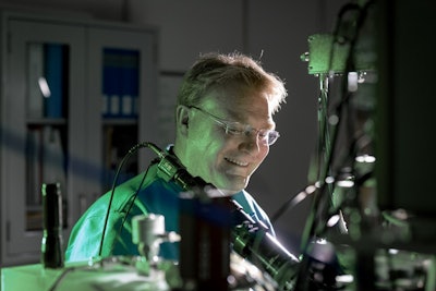 Sandia National Laboratories’ Ed Bielejec examines a material at the Ion Beam Laboratory with the Nano-Implanter, a machine that produces very precise material defects. Image and caption credit: Rebecca Gustaf / Sandia National Laboratories