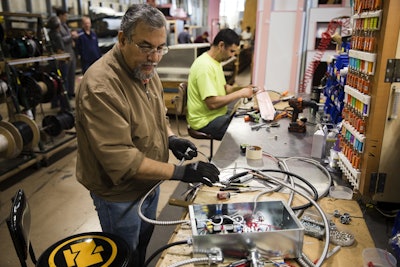 In this Thursday, Oct. 18, 2018, photo Sarmad Eskandar, left, and Mustpha Damen work on electrical components at the Howard McCray's commercial refrigeration manufacturing facility in Philadelphia. Image credit: AP Photo/Matt Rourke