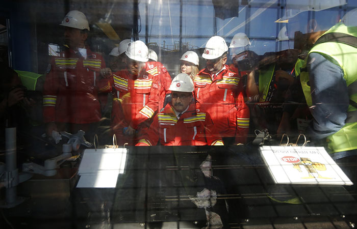 In this photo taken on Tuesday, Oct. 30, 2018, Fatih Donmez, center, Turkey's energy and natural resources minister talks sits in the drill control room during a visit to Turkey's new drillship 'Conquerer' off the coast of Antalya, southern Turkey. Turkey says it has begun a search for oil and gas in east Mediterranean waters in a move that could stoke regional tensions. The drillship ‘Conquerer’ began exploratory drilling Wednesday off Antalya on Turkey’s southern coast. (AP Photo/Lefteris Pitarakis)