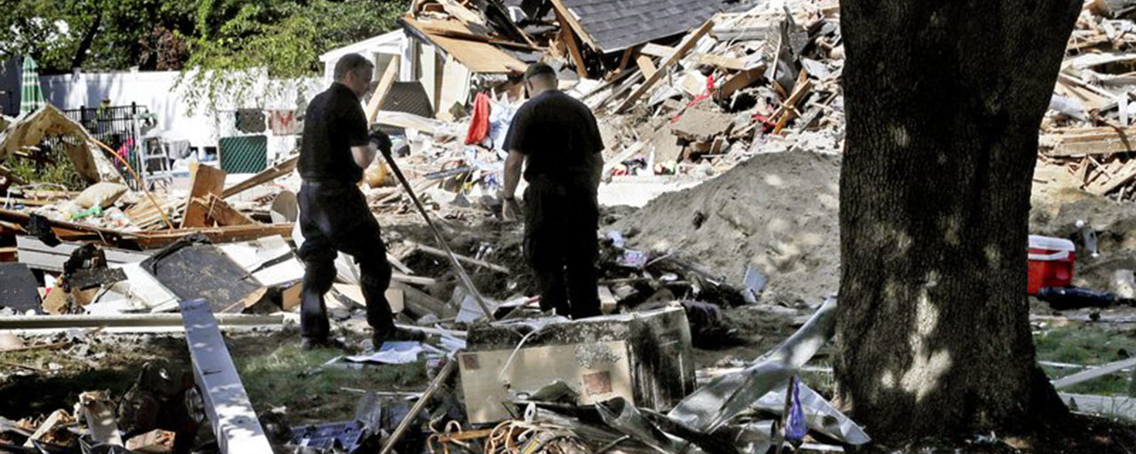 In this Sept. 21, 2018 file photo, fire investigators pause while searching the debris at a home which exploded following a gas line failure in Lawrence, Mass. Federal prosecutors have been conducting a criminal investigation into the natural gas explosions and fires that rocked three communities north of Boston in September. NiSource, the parent company of Columbia Gas of Massachusetts, disclosed Thursday, Nov. 1, it is cooperating with a criminal investigation by U.S. Attorney for Massachusetts Andrew Lelling’s office. The Indiana-based utility made the disclosure in its quarterly financial disclosure report to the U.S. Securities and Exchange Commission. (AP Photo/Charles Krupa, File)