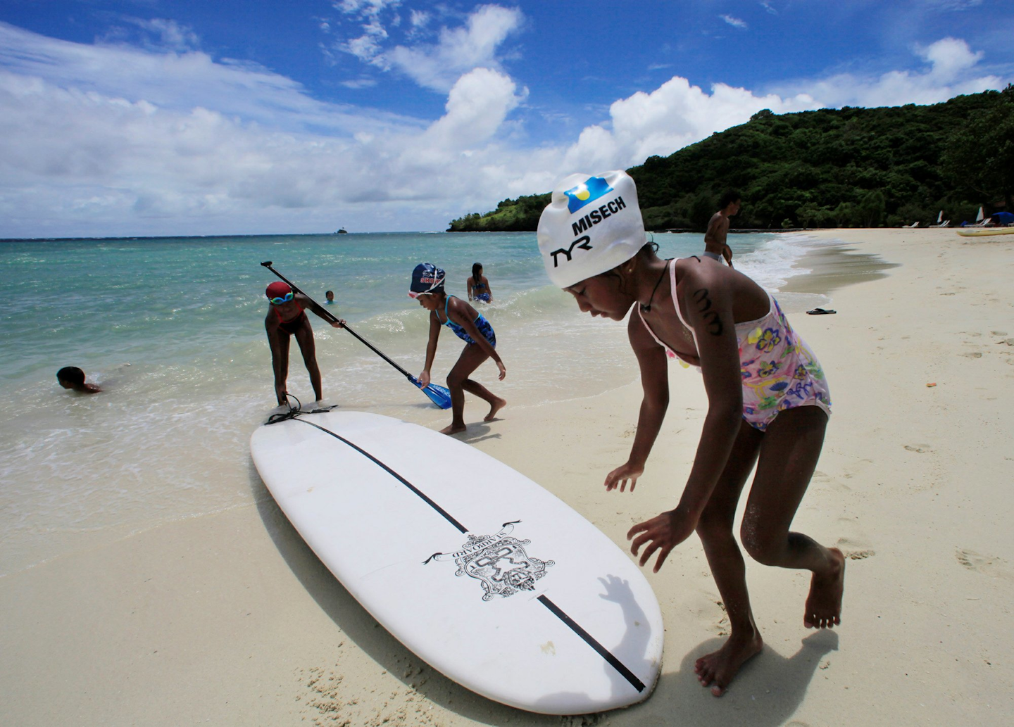 In this June 13, 2009 file photo, children play at a resort beach in Ngerkebesang, Palau. In an attempt to protect the coral reefs that divers so admire they have dubbed them the underwater Serengeti, the Pacific nation of Palau will soon ban many types of sunscreen. President Tommy Remengesau Jr. Oct. 25, 2018, signed legislation that bans 'reef-toxic' sunscreen from 2020. Banned sunscreens will be confiscated from tourists who carry them into the country, and merchants selling the banned products will be fined up to $1,000. (AP Photo/Itsuo Inouye)