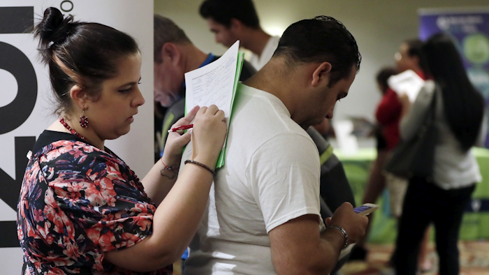 In this Jan. 30, 2018, file photo, Loredana Gonzalez, of Doral, Fla., fills out a job application at a JobNewsUSA job fair in Miami Lakes, Fla. Image credit: AP Photo/Lynne Sladky, File