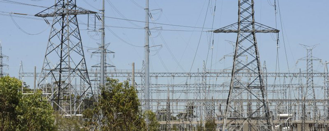 In this Nov. 3, 2009, file photo, powerlines run across a section near Brisbane. Households will pay significantly more for their power when a proposed Emissions Trading Scheme is introduced. The Australian government on Wednesday warned it intends to block a Hong Kong and Chinese consortium’s 13 billion Australian dollar ($9 billion) takeover bid for an energy infrastructure company because it conflicts with Australia’s national interest. (Dave Hunt/AAP Image via AP)