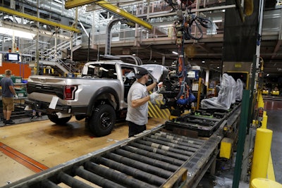 In this Sept. 27, 2018, file photo a United Auto Workers assemblyman installs seating in a 2018 Ford F-150 truck being assembled at the Ford Rouge assembly plant in Dearborn, Mich. Image credit: AP Photo/Carlos Osorio, File