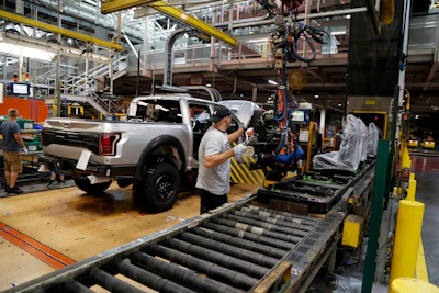 In this Sept. 27, 2018, file photo a United Auto Workers assemblyman installs seating in a 2018 Ford F-150 truck being assembled at the Ford Rouge assembly plant in Dearborn, Mich. Image credit: AP Photo/Carlos Osorio, File