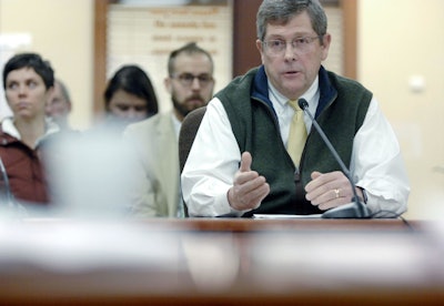 Jeff Hume, an official with Oklahoma-based Continental Resources, testifies during a public hearing in front of members of the North Dakota Oil and Gas Division on Tuesday in Bismarck. The hearing was about proposed changes to state regulations dealing with Bakken crude oil and safe rail transportation. Behind Hume is Scott Skokos, executive director of Dakota Resource Council. (The Bismark Tribune)