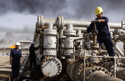 In this Dec. 13, 2009 file photo, Iraqi laborers work at the Rumaila oil refinery in Zubair near the city of Basra, Iraq. Iraq's Oil Ministry says Iraq has resumed exports from its oil fields around Kirkuk, one year after the city was seized by federal forces from the autonomous Kurdish administration in the north of the country. (AP Photo/Nabil al-Jurani)
