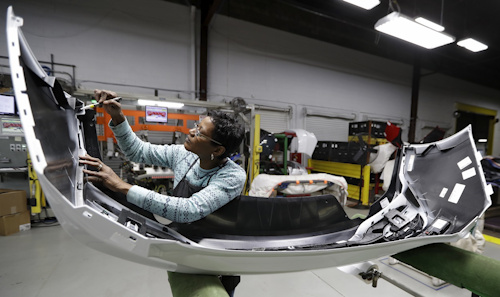 In this Nov. 28, 2018, file photo final inspector Mary Skinner inspects the rear end of a General Motors Chevrolet Cruze at Jamestown Industries in Youngstown, Ohio. Image credit: AP Photo/Tony Dejak, File