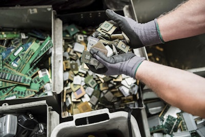 In this photo taken on July 13, 2018, a worker handles components of electronic elements at the Out Of Use company warehouse in Beringen, Belgium. Image credit: AP Photo/Geert Vanden Wijngaert