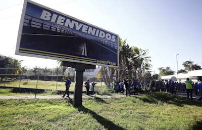 A Goodyear billboard emblazoned with the Spanish word for welcome, is posted near a plant entrance company where workers arrived to find the plant is no longer in operation, in Los Guayabos, Venezuela, Monday, Dec. 10, 2018. Image credit: AP Photo/Juan Carlos Hernandez