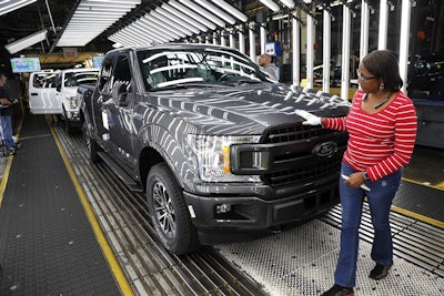 In this Sept. 27, 2018, file photo United Auto Workers' assemblyman Kelly Coman gives a final look to an assembled 2018 Ford F-150 truck on the assembly line at the Ford Rouge assembly plant in Dearborn, Mich. Image credit: AP Photo/Carlos Osorio, File