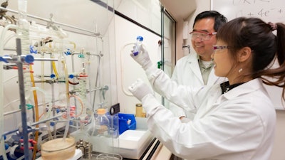 Argonne chemist Lina Chong (foreground) holds a sample catalyst while Argonne chemist Di-Jia Liu looks on. (Argonne National Laboratory)