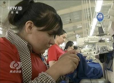 In this file image from undated video footage run by China's CCTV via AP Video, Muslim trainees work in a garment factory in the Hotan Vocational Education and Training Center in Hotan, Xinjiang, northwest China. Image credit: CCTV via AP Video, File