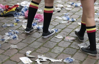 In this June 18, 2016 file photo two Belgian fans, wearing the Belgian colors, walk through plastic cups and other garbage after taking part in a celebration in Antwerp, Belgium, after Belgium won its Euro 2016 Group E match against Ireland. Image credit: AP Photo/Virginia Mayo, file