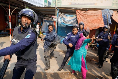 A Bangladeshi garment worker clashes with policemen during a protest in Savar, on the outskirts of Dhaka, Bangladesh, Wednesday, Jan. 9, 2019. (AP Photo)
