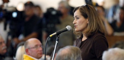 In this Sept. 11, 2010, file photo, Geisha Williams, right, then-senior vice president of energy delivery for Pacific Gas & Electric, speaks to hundreds of displaced San Bruno residents that jammed a town hall meeting at St. Roberts Catholic Church in San Bruno, Calif. Image credit: AP photo/Tony Avelar, File