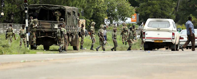 Zimbabwean soldiers are situated where police are clashing with protestors over fuel hikes in Harare, Zimbabwe, Monday, Jan. 14, 2019. Zimbabwean police on Monday fired tear gas in suburbs of the capital an attempt to disperse angry demonstrators who burned tires and threw stones to protest fuel price hikes. (AP Photo/Tsvangirayi Mukwazhi)