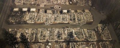 This Thursday, Nov. 15, 2018, file aerial photo shows the remains of residences leveled by the wildfire in Paradise, Calif. Facing potentially colossal liabilities over deadly California wildfires, PG&E will file for bankruptcy protection. The announcement Monday, Jan. 14, 2019, follows the resignation of the power company’s chief executive. (AP Photo/Noah Berger)
