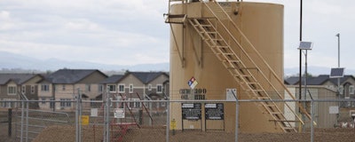 In this May 27, 2016 file photograph, tanks sit near a housing development off state highway 119 near Firestone, Colo., in the Wattenberg Field, Colorado’s most productive oil and gas area. The Colorado Supreme Court ruled Monday, Jan. 14, 201,9 that state law does not allow regulators to make public and health and environment their top priority when setting rules for oil and gas drilling. (AP Photo/David Zalubowski)