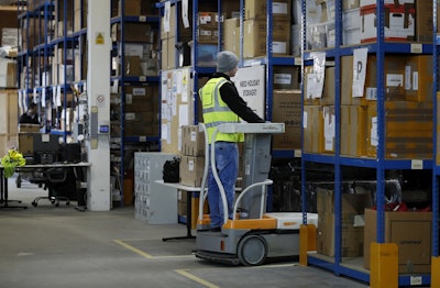 Lovespace warehouse worker Piotr Waligora, works on an electronic lift to place boxes and goods in their allocated zones at the warehouse in Dunstable, England Monday, Jan. 14, 2019. Image credit: AP Photo/Alastair Grant