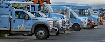 Pacific Gas & Electric vehicles are parked at the PG&E Oakland Service Center, Monday, Jan. 14, 2019, in Oakland, Calif. Facing potentially colossal liabilities over deadly California wildfires, PG&E will file for bankruptcy protection. The announcement today follows the resignation of the power company's chief executive. (AP Photo/Ben Margot)