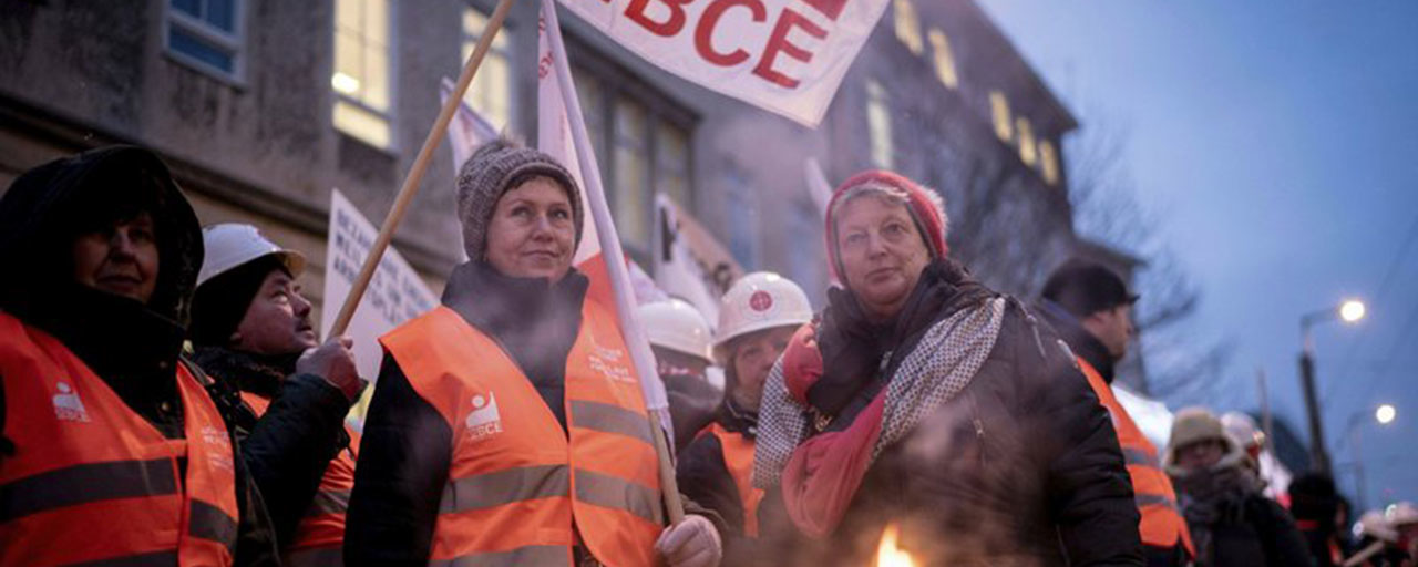 Union protesters hold flags prior to a meeting of a panel of experts on the exit of the using coal called 'Coal Commission' in Berlin, Germany, Friday, Jan. 25, 2019. Germany wants to stop using coal, a major source of the carbon emissions that drive climate change. (Kay Nietfeld/dpa via AP)