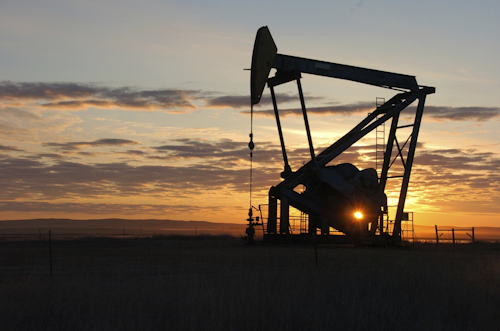 This Nov. 6, 2013 file photo shows a Whiting Petroleum Co. pump jack pulls crude oil from the Bakken region of the Northern Plains near Bainville, Mont. Image credit: AP Photo/Matthew Brown, File
