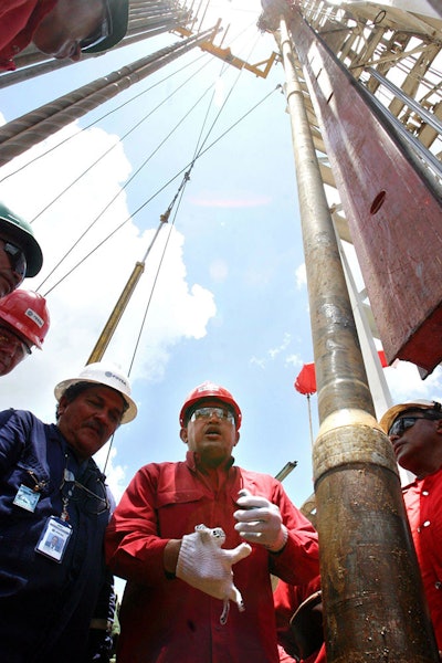 In this Aug. 10, 2006 file photo, Venezuela's late President Hugo Chavez visits oil workers on the platform of an oil drill at Carabobo block one in the Orinoco oil belt in Venezuela's Anzoategui state. Venezuela was once one of the world's top five oil exporters, pumping 3.5 million barrels a day in 1998 when President Hugo Chavez was elected and launched Venezuela's Bolivarian revolution. Today in 2019, the state-run oil company PDVSA produces less than a third of that. (AP Photo)