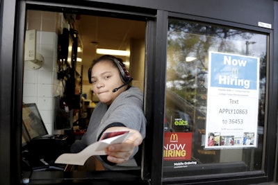 In this Jan. 3, 2019, file photo a cashier returns a credit card and a receipt at a McDonald's window, where signage for job openings are displayed in Atlantic Highlands, N.J. Image credit: AP Photo/Julio Cortez, File