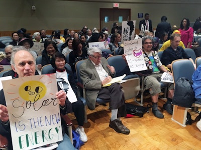 Opponents of a planned gas-fired power plant for eastern New Orleans are part of the crowd gathered for a city council committee hearing on Thursday, Feb. 14, 2019 in New Orleans. Image credit: AP Photo/Kevin McGill