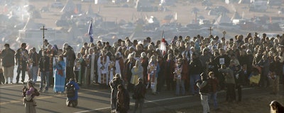 This Nov. 11, 2016 file photo shows more than 500 clergy from across the country gathered for a 'Clergy for Standing Rock' march on N.D. Highway 1806 near Cannon Ball, N. D., from the Oceti Sakowin Camp to the Cantapeta Creek bridge to demonstrate their solidarity for the Dakota Access Pipeline protesters. South Dakota Gov. Kristi Noem says she's proposing legislation ahead of the Keystone XL oil pipeline's construction that would create a legal avenue to pursue out-of-state money that funds protests aimed at slowing construction. Noem's bills come after opponents of the Dakota Access oil pipeline staged large protests that resulted in 761 arrests in southern North Dakota over a six-month span beginning in late 2016. The state spent tens of millions of dollars policing the protests. (Mike McCleary/The Bismarck Tribune via AP)