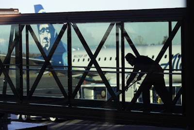 In this March 4, 2019, file photo a worker cleans a jet bridge before passengers boarded an Alaska Airlines flight to Portland, Ore., at Paine Field in Everett, Wash. Image credit: AP Photo/Ted S. Warren, File