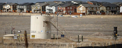In this Feb. 28, 2019, photograph, a storage tank stands near a well pad located in a field near a housing development in Broomfield, Colo. Frustrated residents of a Denver suburb say state law is forcing them to participate in a major oil and gas drilling project against their wishes, so they launched legal challenges with potentially significant consequences for the industry. Backed by a federal judge, they have a chance this week to ask state regulators to block multiple wells planned within about 1,300 feet (400 meters) of homes in the city of Broomfield. (AP Photo/David Zalubowski)