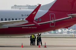 Ground crew chat near a Boeing 737 MAX 8 plane operated by Shanghai Airlines parked on tarmac at Hongqiao airport in Shanghai, China, Tuesday, March 12, 2019. Image credit: AP Photo